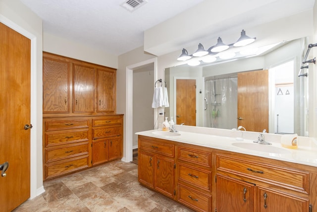 3701 Regency Dr, Deer Park, TX 77536 - bathroom featuring double vanity, a shower, and stone finish flooring