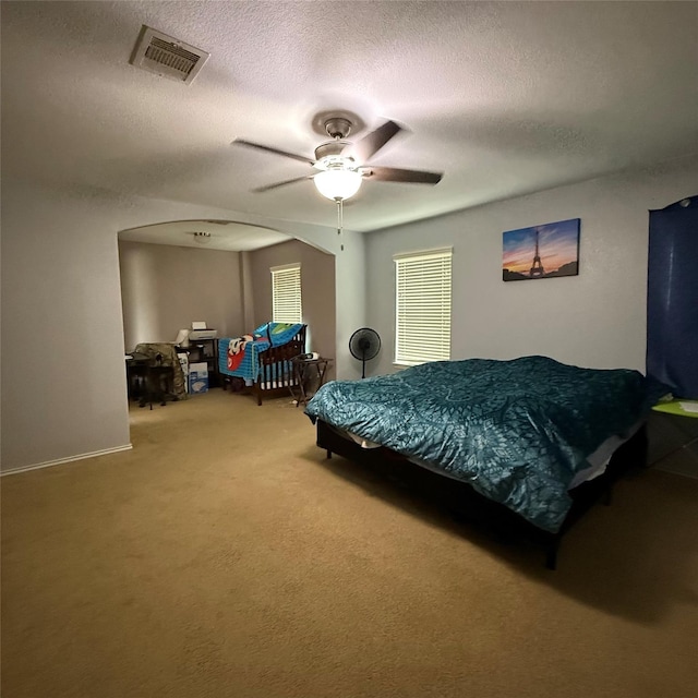 3619 Robwood Ct, Katy, TX 77449 - bedroom featuring light colored carpet, a textured ceiling, arched walkways, and a ceiling fan