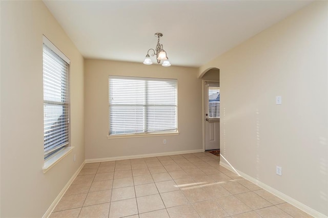 15807 Sarasam Creek Ct, Cypress, TX 77429 - unfurnished room with plenty of natural light, a chandelier, arched walkways, and light tile patterned floors