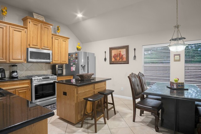 9827 Kimberly Loch Ln, Houston, TX 77089 - kitchen with stainless steel appliances, lofted ceiling, decorative backsplash, a center island, and light tile patterned flooring
