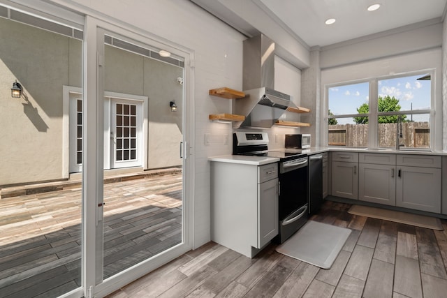 6510 Brady Springs Ct, Sugar Land, TX 77479 - kitchen with stainless steel range with electric stovetop, gray cabinets, wall chimney exhaust hood, wood finished floors, and recessed lighting