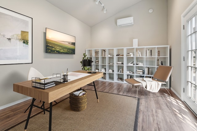 6510 Brady Springs Ct, Sugar Land, TX 77479 - office with wood finished floors, a wall unit AC, high vaulted ceiling, and rail lighting