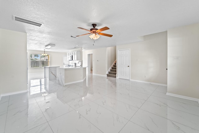1022 Vera Cruz Dr, Rosenberg, TX 77471 - unfurnished living room featuring stairs, light marble finish flooring, ceiling fan, and a textured ceiling