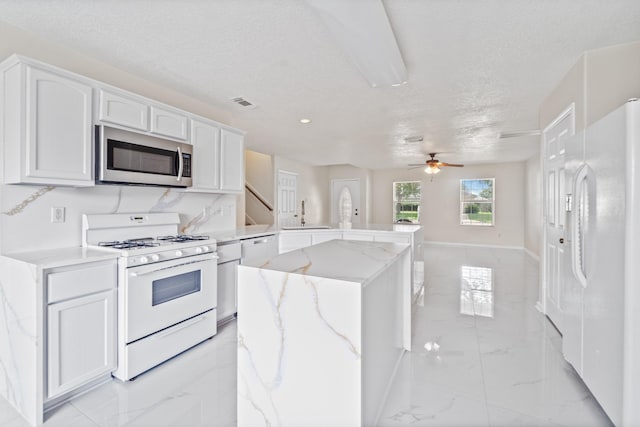 1022 Vera Cruz Dr, Rosenberg, TX 77471 - kitchen featuring white appliances, light marble finish flooring, a peninsula, a ceiling fan, and white cabinetry
