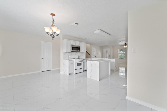 1022 Vera Cruz Dr, Rosenberg, TX 77471 - kitchen with stainless steel microwave, white gas range oven, open floor plan, light marble finish flooring, and light countertops
