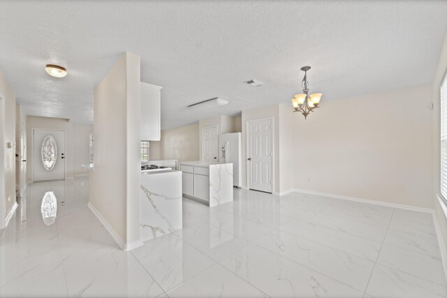 1022 Vera Cruz Dr, Rosenberg, TX 77471 - interior space with light marble finish floors, a chandelier, and a textured ceiling
