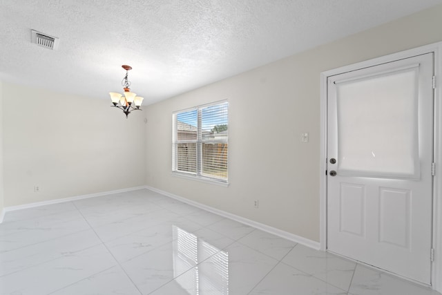 1022 Vera Cruz Dr, Rosenberg, TX 77471 - spare room featuring light marble finish flooring, a chandelier, and a textured ceiling