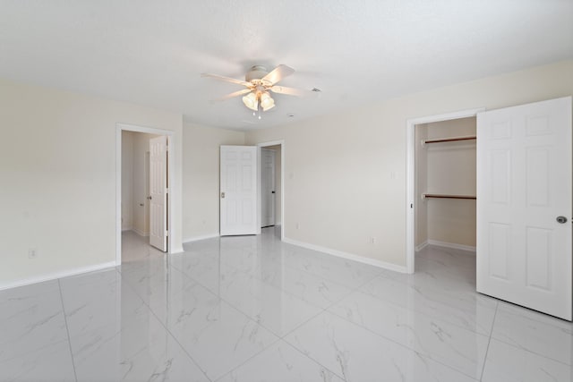 1022 Vera Cruz Dr, Rosenberg, TX 77471 - unfurnished bedroom featuring a walk in closet, light marble finish flooring, a ceiling fan, and a closet