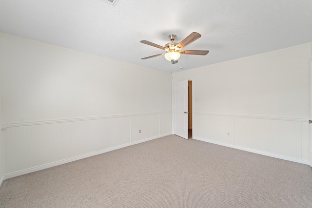 1022 Vera Cruz Dr, Rosenberg, TX 77471 - empty room featuring a ceiling fan, a wainscoted wall, and carpet flooring