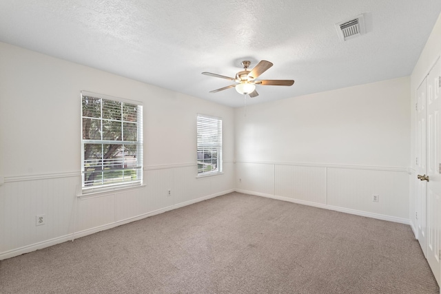 1022 Vera Cruz Dr, Rosenberg, TX 77471 - empty room with ceiling fan, wainscoting, carpet flooring, and a textured ceiling