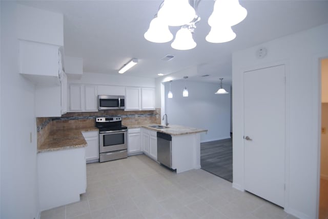 6503 Gladewell Dr, Houston, TX 77072 - kitchen with appliances with stainless steel finishes, a peninsula, decorative backsplash, white cabinetry, and a chandelier