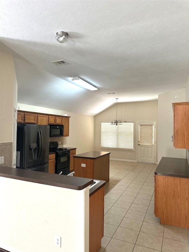 1005 Summer Park Blvd, Conroe, TX 77303 - kitchen featuring black appliances, dark countertops, lofted ceiling, a center island, and light tile patterned flooring