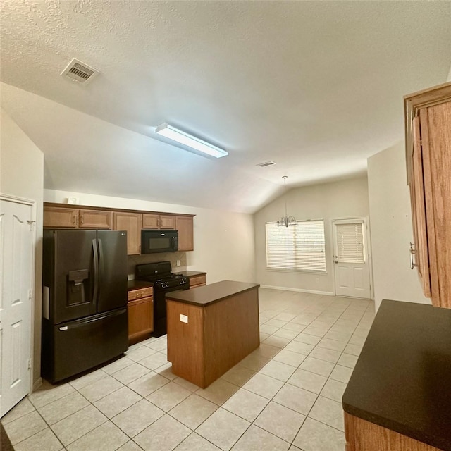 1005 Summer Park Blvd, Conroe, TX 77303 - kitchen featuring black appliances, vaulted ceiling, dark countertops, light tile patterned flooring, and a kitchen island