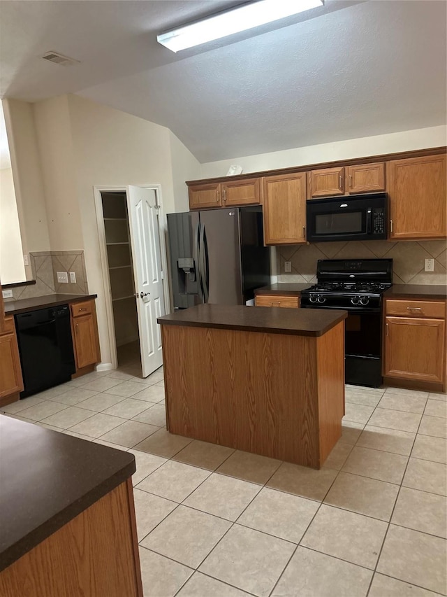 1005 Summer Park Blvd, Conroe, TX 77303 - kitchen featuring black appliances, dark countertops, lofted ceiling, light tile patterned floors, and decorative backsplash