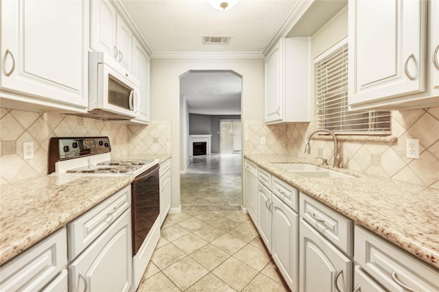 12550 Whittington Dr Unit 816, Houston, TX 77077 - kitchen featuring white appliances, arched walkways, a textured ceiling, white cabinetry, and light stone counters