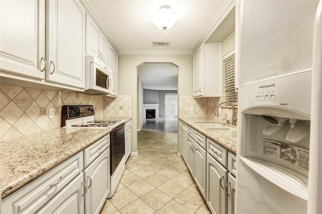 12550 Whittington Dr Unit 816, Houston, TX 77077 - kitchen featuring white appliances, arched walkways, white cabinets, a textured ceiling, and light tile patterned flooring