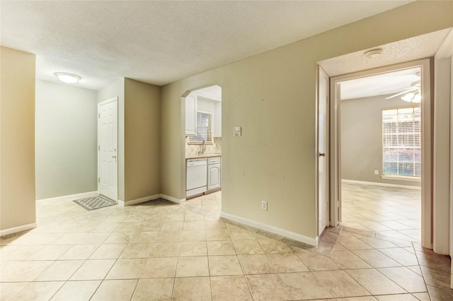 12550 Whittington Dr Unit 816, Houston, TX 77077 - spare room featuring light tile patterned floors, arched walkways, a textured ceiling, a smoke detector, and a ceiling fan
