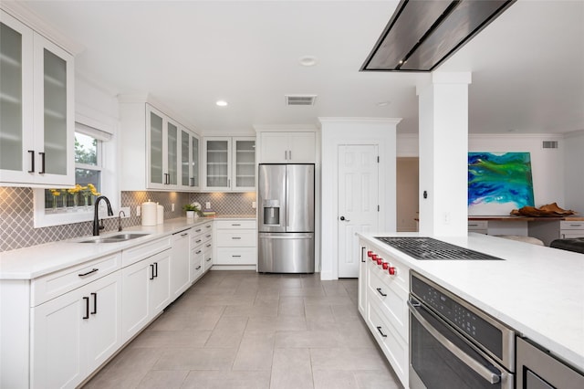 8932 Padfield St, Houston, TX 77055 - kitchen with stainless steel appliances, decorative backsplash, light countertops, ornamental molding, and white cabinets