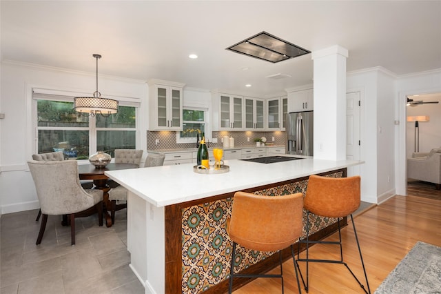 8932 Padfield St, Houston, TX 77055 - kitchen featuring stainless steel fridge, light countertops, tasteful backsplash, white cabinetry, and crown molding
