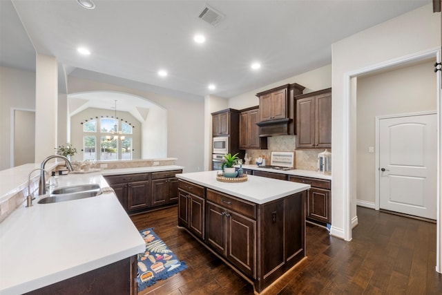 1504 Moreland Park Ct, Friendswood, TX 77546 - kitchen with appliances with stainless steel finishes, light countertops, dark wood-type flooring, decorative backsplash, and dark brown cabinetry