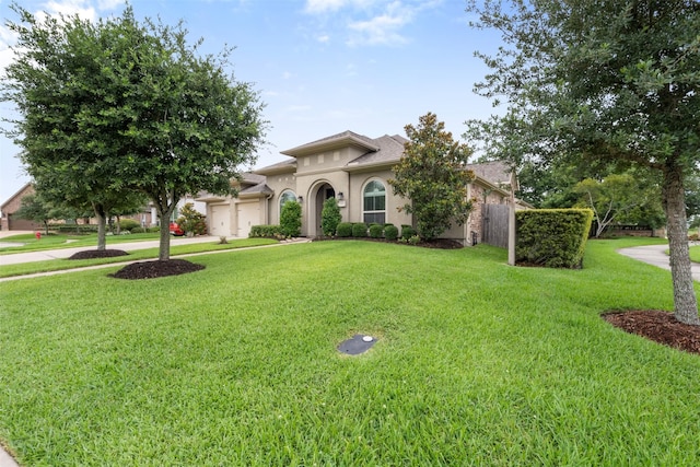1504 Moreland Park Ct, Friendswood, TX 77546 - mediterranean / spanish-style house featuring a garage, a front yard, concrete driveway, and stucco siding