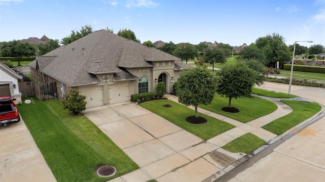 1504 Moreland Park Ct, Friendswood, TX 77546 - view of front facade with a shingled roof, driveway, a front yard, an attached garage, and stucco siding