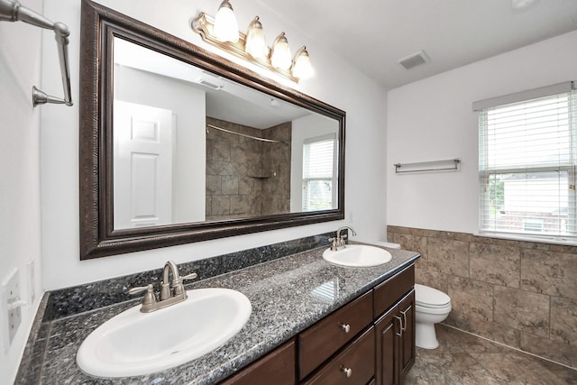 2508 Sun Glen Dr, Pearland, TX 77584 - bathroom with double vanity, tile walls, a shower, and wainscoting