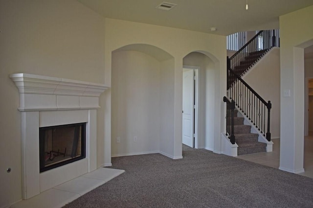 7615 Adobe Canyon Ln, Richmond, TX 77469 - unfurnished living room with carpet flooring, a fireplace, stairway, and arched walkways