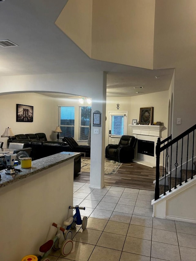 7615 Adobe Canyon Ln, Richmond, TX 77469 - living room with light tile patterned floors, stairway, a fireplace, and a high ceiling