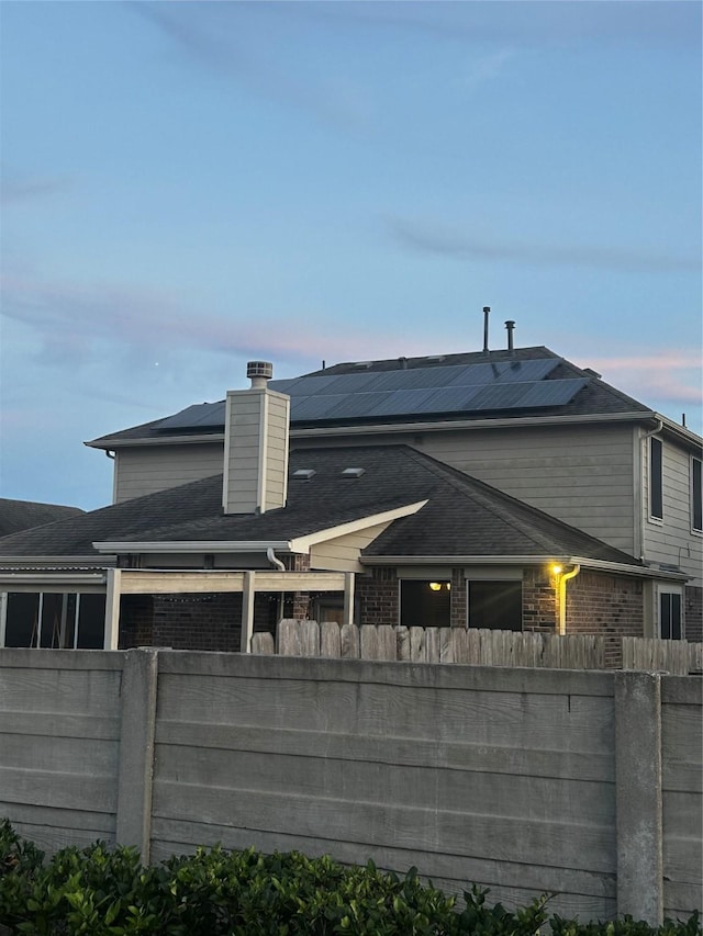 7615 Adobe Canyon Ln, Richmond, TX 77469 - back of property with brick siding, roof mounted solar panels, and a chimney