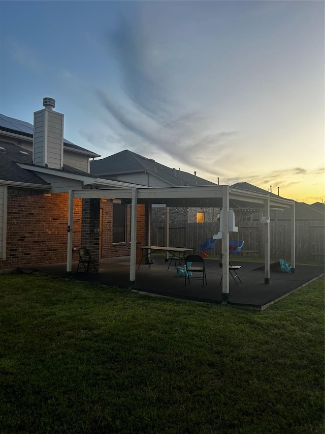 7615 Adobe Canyon Ln, Richmond, TX 77469 - rear view of property featuring a patio, brick siding, a chimney, and a playground