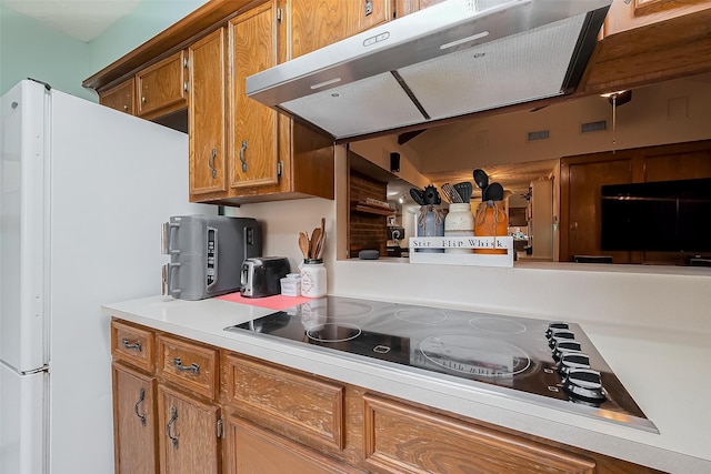 327 Edgeton Ct, Houston, TX 77015 - kitchen featuring extractor fan, brown cabinetry, black electric stovetop, light countertops, and freestanding refrigerator
