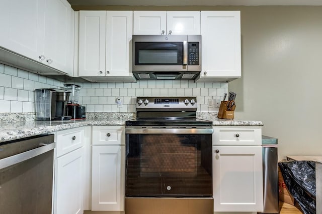 8206 Bassett St, Houston, TX 77051 - kitchen with appliances with stainless steel finishes, white cabinetry, decorative backsplash, and light stone counters