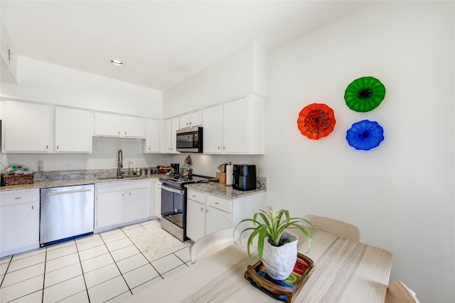 1572 Prairie Grove Dr, Houston, TX 77077 - kitchen featuring stainless steel appliances, white cabinets, light tile patterned flooring, and recessed lighting