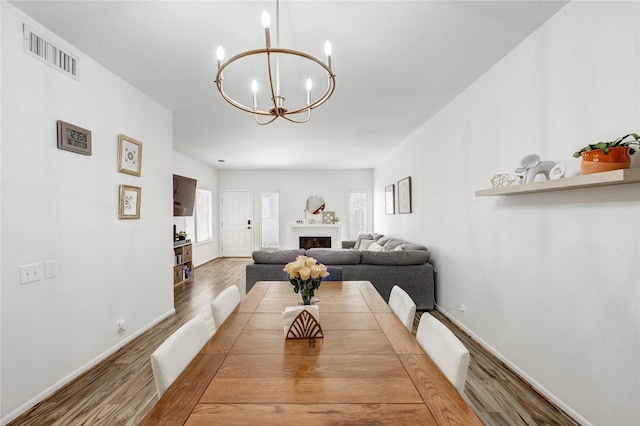 1572 Prairie Grove Dr, Houston, TX 77077 - dining space featuring wood finished floors, a chandelier, and a fireplace