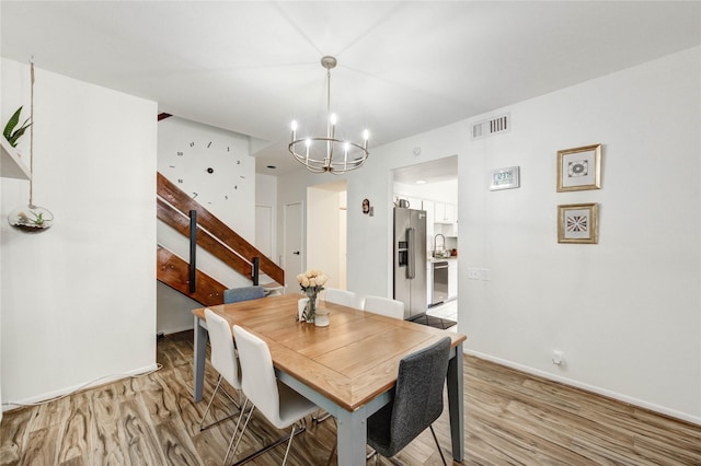 1572 Prairie Grove Dr, Houston, TX 77077 - dining room with a chandelier, stairs, and light wood-style floors