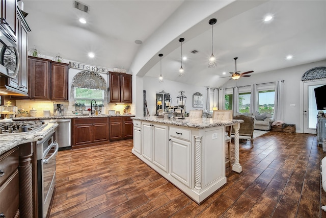 6507 Crystal Forest Trl, Katy, TX 77493 - kitchen with ceiling fan, dark wood-style floors, open floor plan, vaulted ceiling, and a kitchen breakfast bar
