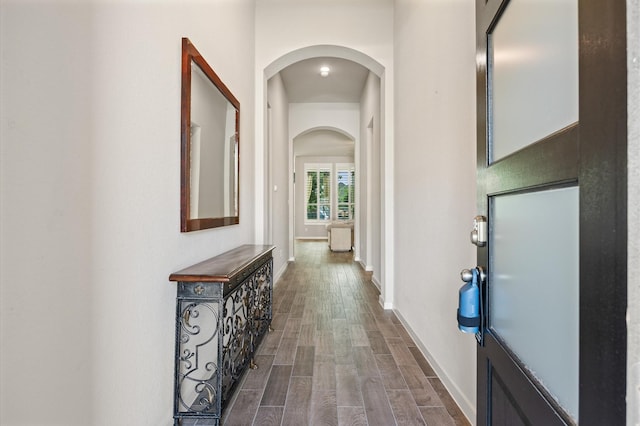 20923 Bradley Gardens Dr, Spring, TX 77379 - hallway with arched walkways and dark wood finished floors