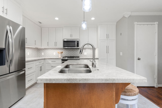 13411 Naples Bridge Rd, Sugar Land, TX 77498 - kitchen featuring appliances with stainless steel finishes, tasteful backsplash, a kitchen island with sink, white cabinets, and crown molding