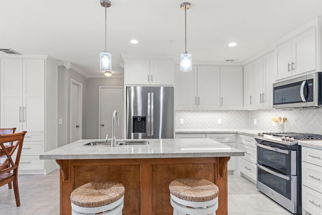 13411 Naples Bridge Rd, Sugar Land, TX 77498 - kitchen featuring stainless steel appliances, light tile patterned floors, backsplash, a breakfast bar area, and a center island with sink