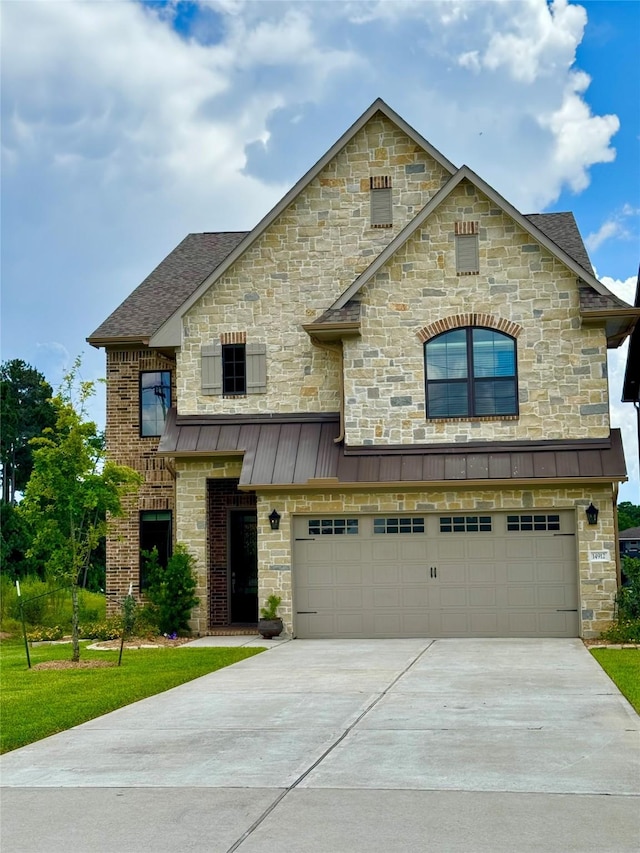 14912 Diamondhead Rd, Conroe, TX 77356 - french country home with concrete driveway, a garage, and a standing seam roof