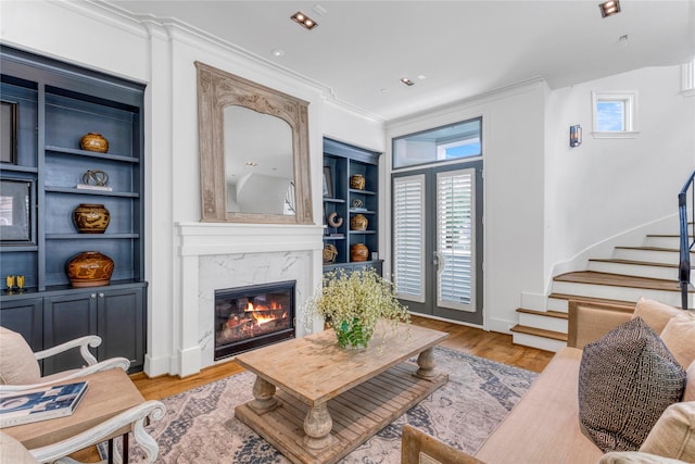 5219 Calle Cordoba Pl, Houston, TX 77007 - living area featuring stairs, a high end fireplace, crown molding, light wood-style floors, and built in features
