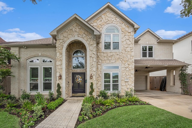 4925 Pine St, Bellaire, TX 77401 - french country style house with an attached garage, concrete driveway, and stone siding