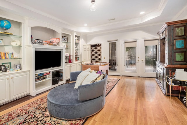 4925 Pine St, Bellaire, TX 77401 - living room with ornamental molding, light wood-type flooring, french doors, built in shelves, and a tray ceiling