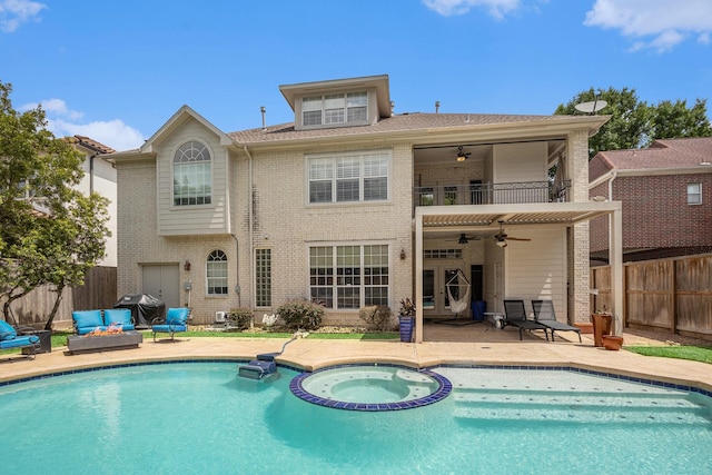 4925 Pine St, Bellaire, TX 77401 - back of property featuring ceiling fan, brick siding, a balcony, a pool with connected hot tub, and a fenced backyard
