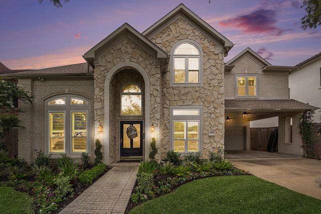 4925 Pine St, Bellaire, TX 77401 - french country inspired facade featuring an attached garage, concrete driveway, stone siding, and brick siding