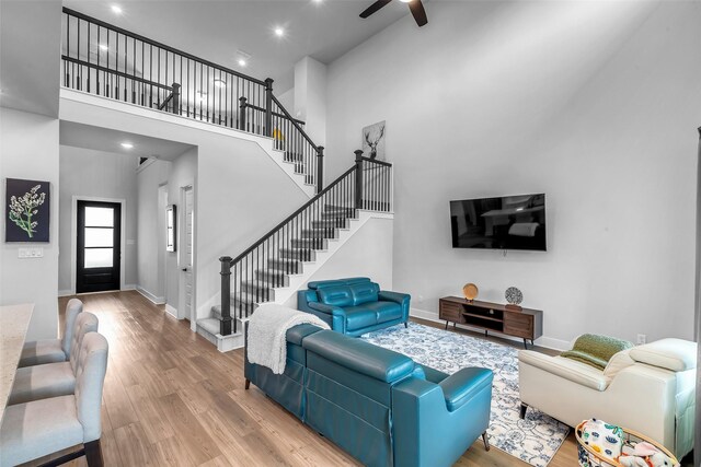 9219 Trimble Landing Dr, Tomball, TX 77375 - living room featuring wood finished floors, stairway, a high ceiling, ceiling fan, and recessed lighting