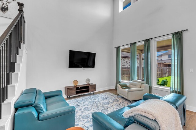 9219 Trimble Landing Dr, Tomball, TX 77375 - living area featuring wood finished floors, a high ceiling, and stairs
