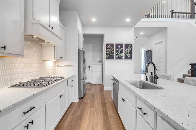 9219 Trimble Landing Dr, Tomball, TX 77375 - kitchen with stainless steel appliances, light wood-style floors, white cabinetry, tasteful backsplash, and recessed lighting