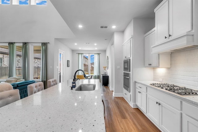 9219 Trimble Landing Dr, Tomball, TX 77375 - kitchen featuring stainless steel appliances, tasteful backsplash, white cabinets, light stone countertops, and recessed lighting